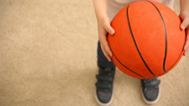child holding basketball