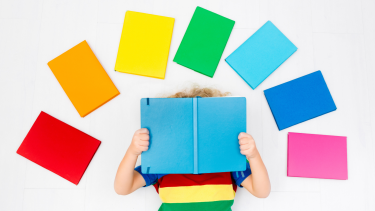 rainbow of books above a child reading