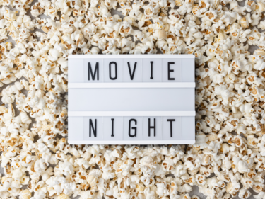 popcorn on floor with a letter board saying movie night