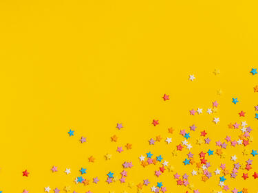colourful star confetti on yellow background