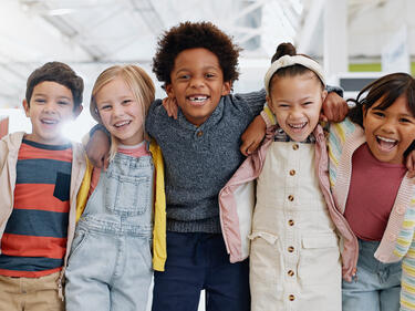 group of diverse children with smiles in school classroom, ready for learning